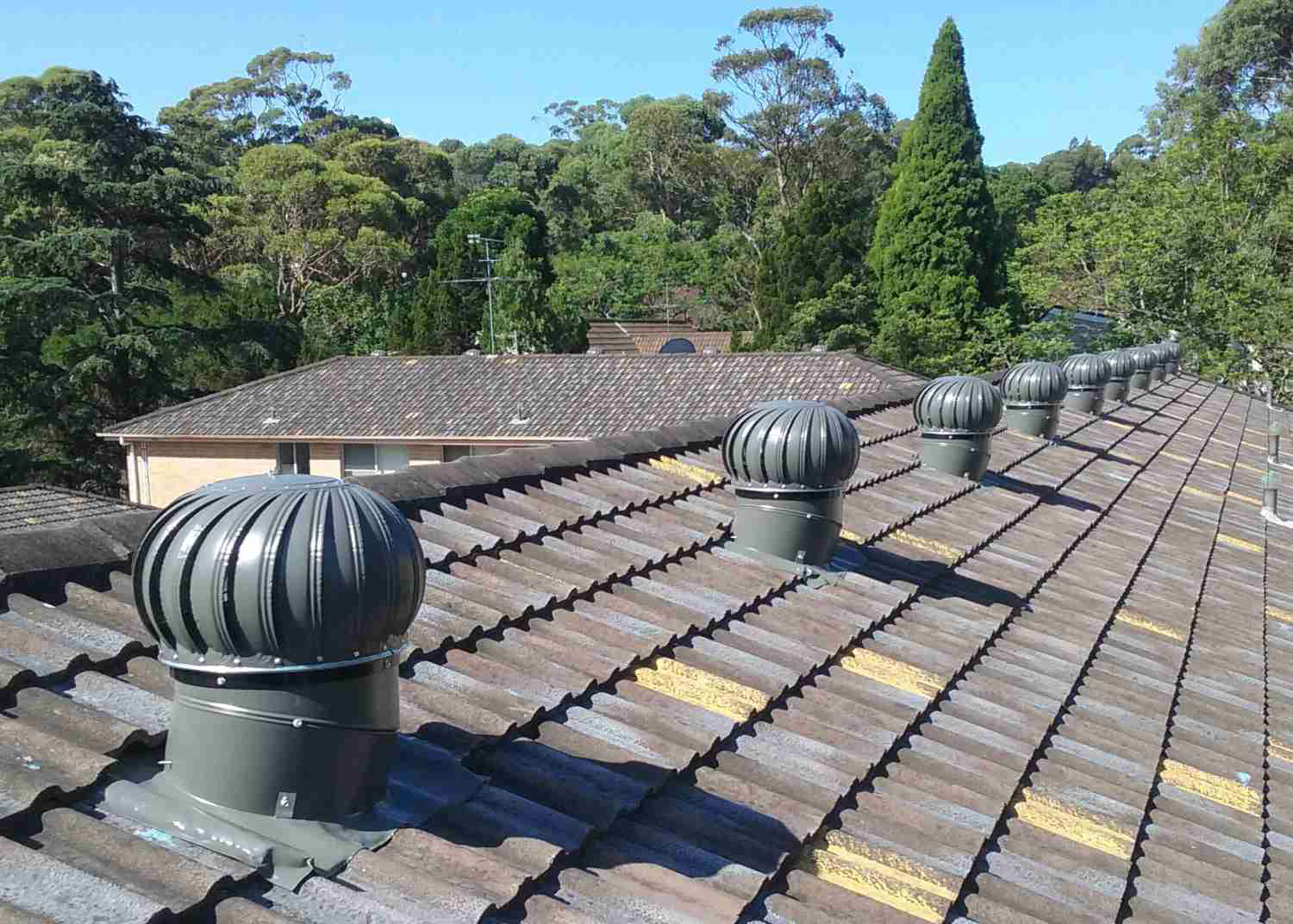Twista whirlybirds product multiple installation grey on concrete tile apartment block roof